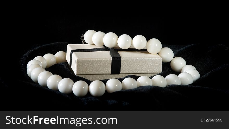 White necklace and gift box on black velvet. White necklace and gift box on black velvet