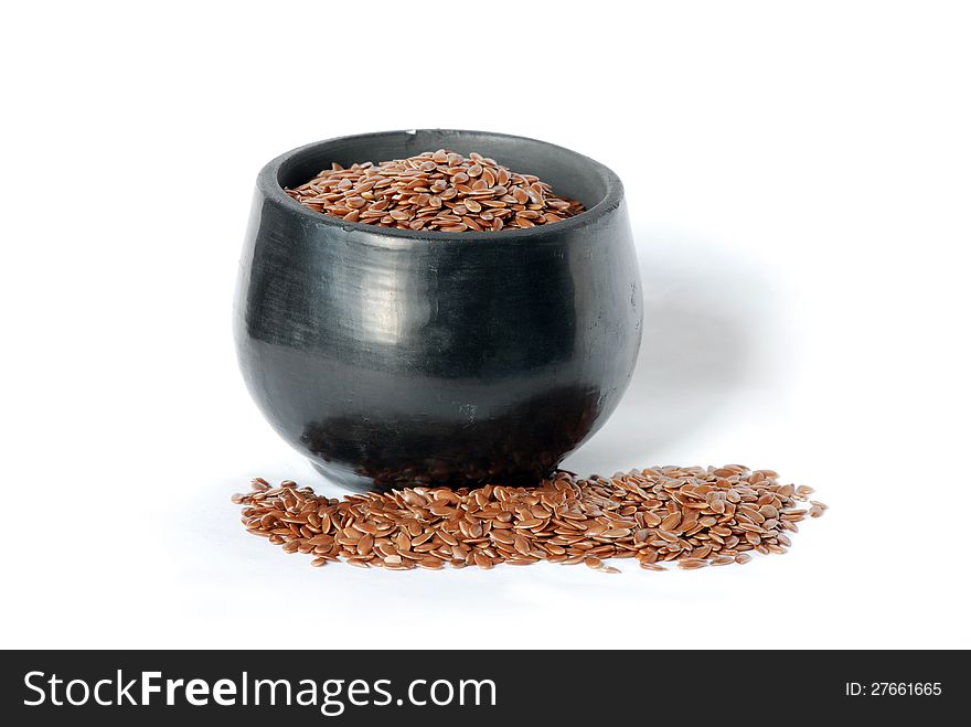 Flaxseed and a black ceramic cup on a white background