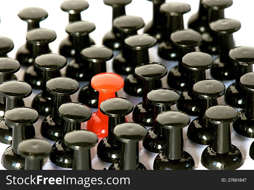 Even array of black pushpin and one red pushpin close-up. Even array of black pushpin and one red pushpin close-up