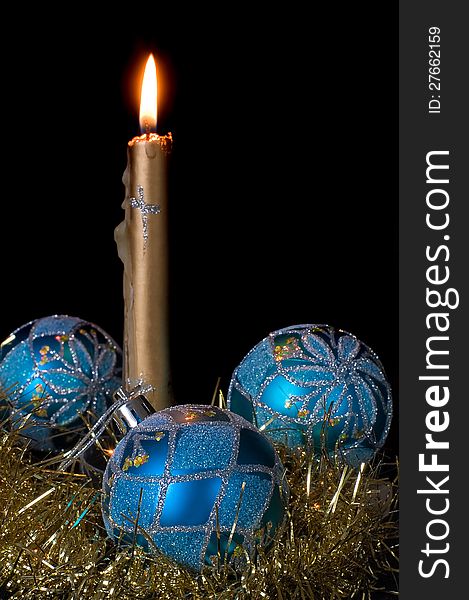 Burning candle and blue Christmas balls on a black background. Burning candle and blue Christmas balls on a black background