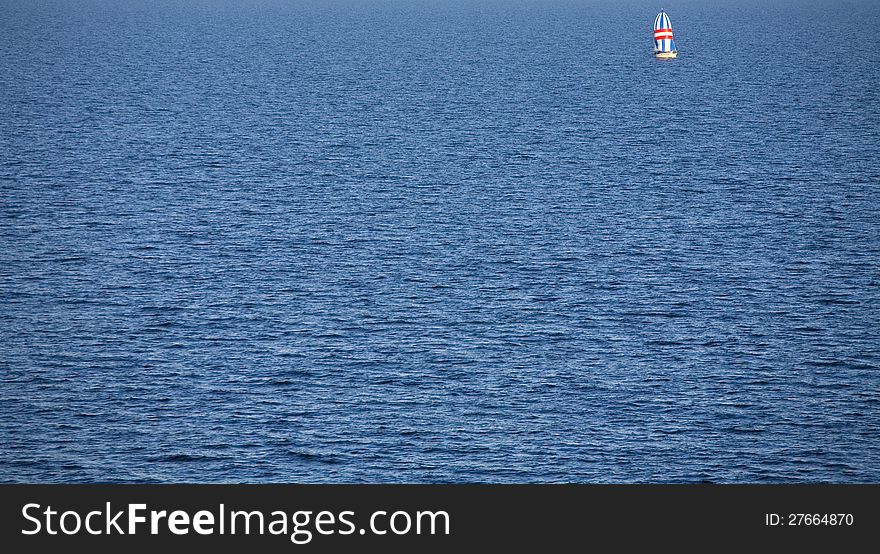 Lonely sailing boat in the middle of an empty lonely sea