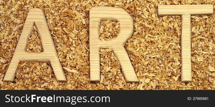 The word ART in the background of sawdust