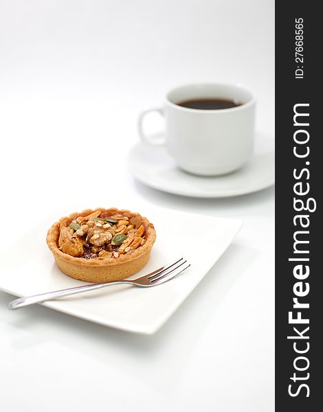 cup cake , caramel nuts tart and a cup of coffee on white background