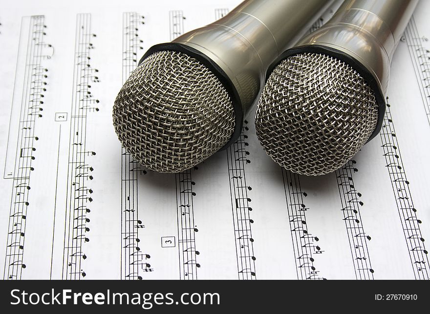 Two metal microphone with music notes. Two metal microphone with music notes