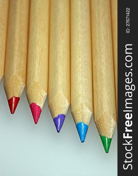 Wooden coloured pencils in line on white background