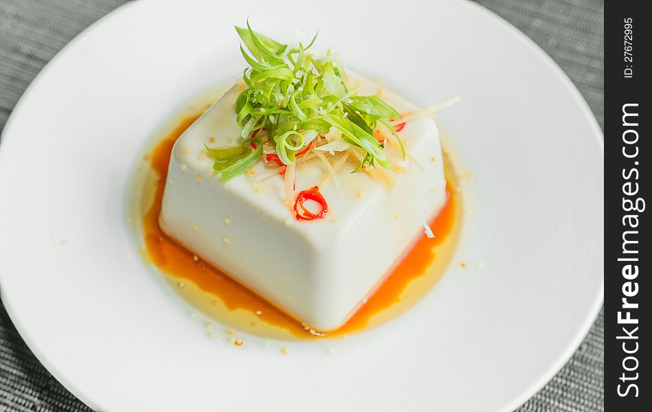 Silken tofu with gochujang and sesame oil decorate with spring onion and ginger