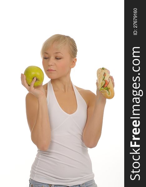 Slim woman choosing between apple and hamburger