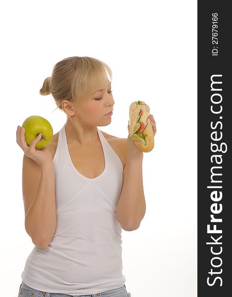 Slim woman choosing between apple and hamburger. isolated on white