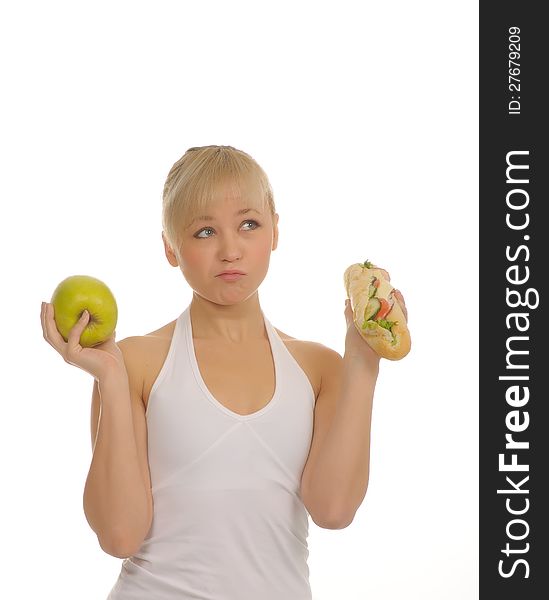 Slim woman choosing between apple and hamburger. isolated on white