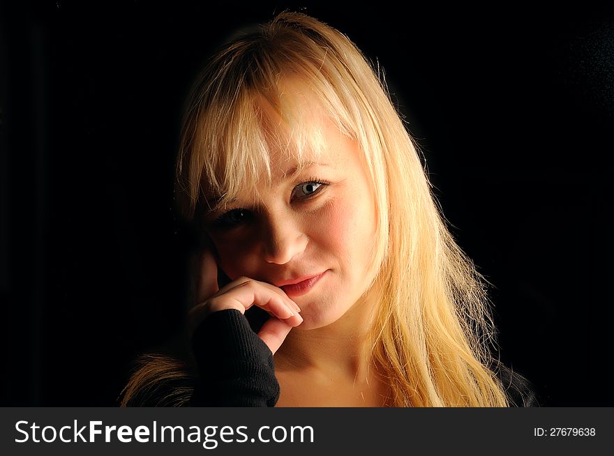 Young blond hair woman portrait on dark background.