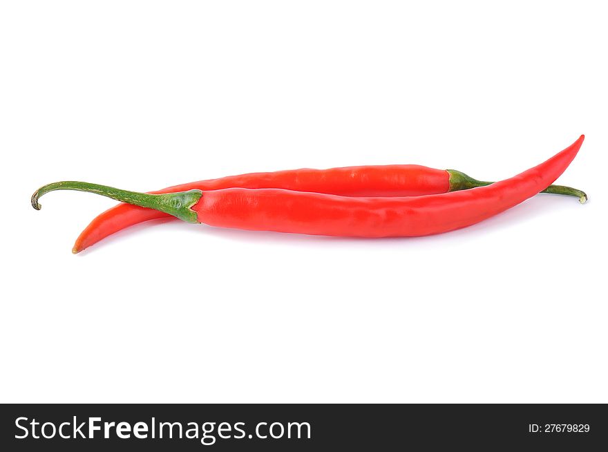 Two red chili peppers on a white