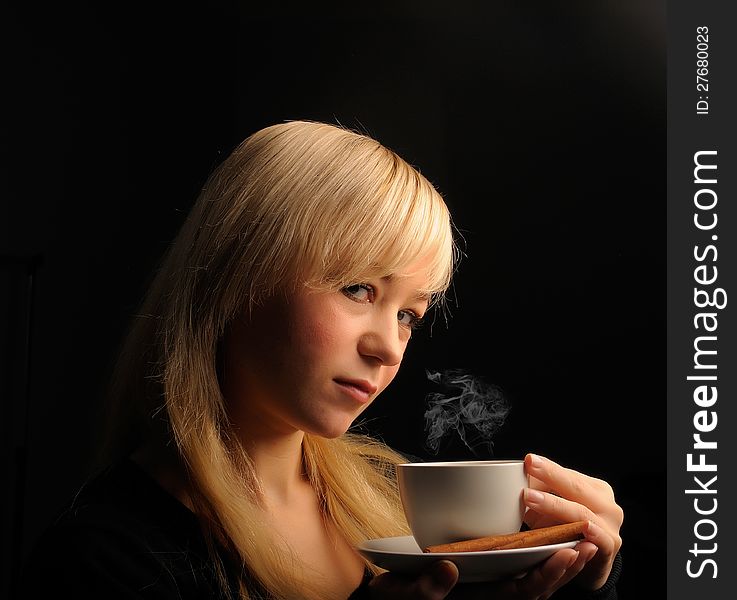 Young blond hair woman with coffe on a dark background. Young blond hair woman with coffe on a dark background.