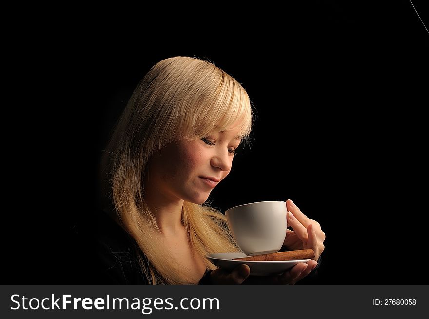 Young blond hair woman with coffe  on a dark background. Young blond hair woman with coffe  on a dark background.