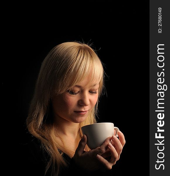 Young blond hair woman with coffee  on a dark background. Young blond hair woman with coffee  on a dark background.