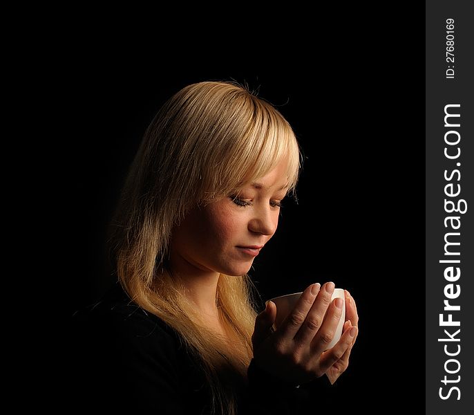 Young blond hair woman with coffee  on a dark background. Young blond hair woman with coffee  on a dark background.