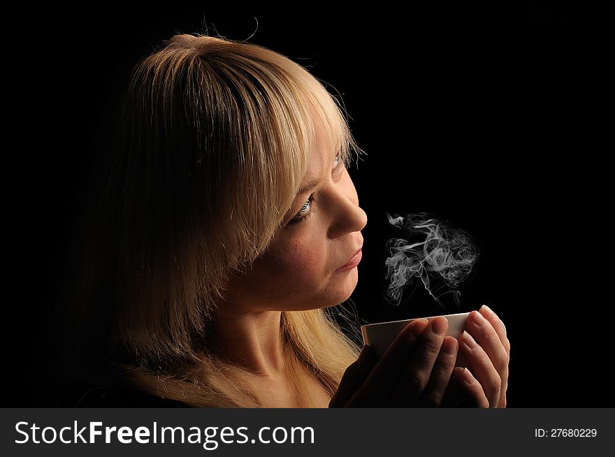 Young blond hair woman with coffee  on a dark background. Young blond hair woman with coffee  on a dark background.