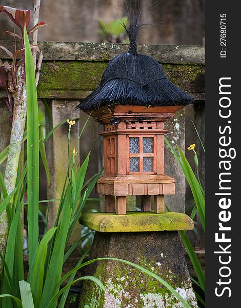 Wooden lantern on a concrete base full of moss