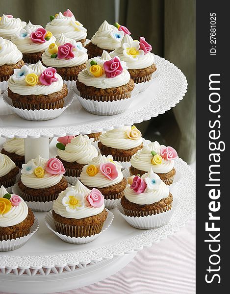 Carrot cupcakes decorated with colorful fondant flowers. Carrot cupcakes decorated with colorful fondant flowers