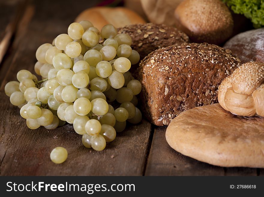 White grapes and bread on wood table. White grapes and bread on wood table