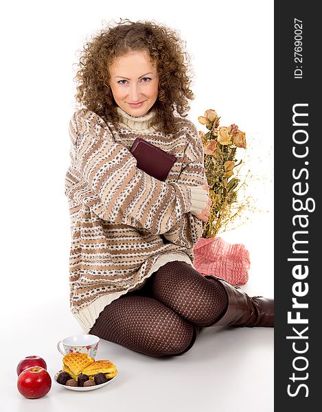 Girl in a sweater with apples and candy and a book