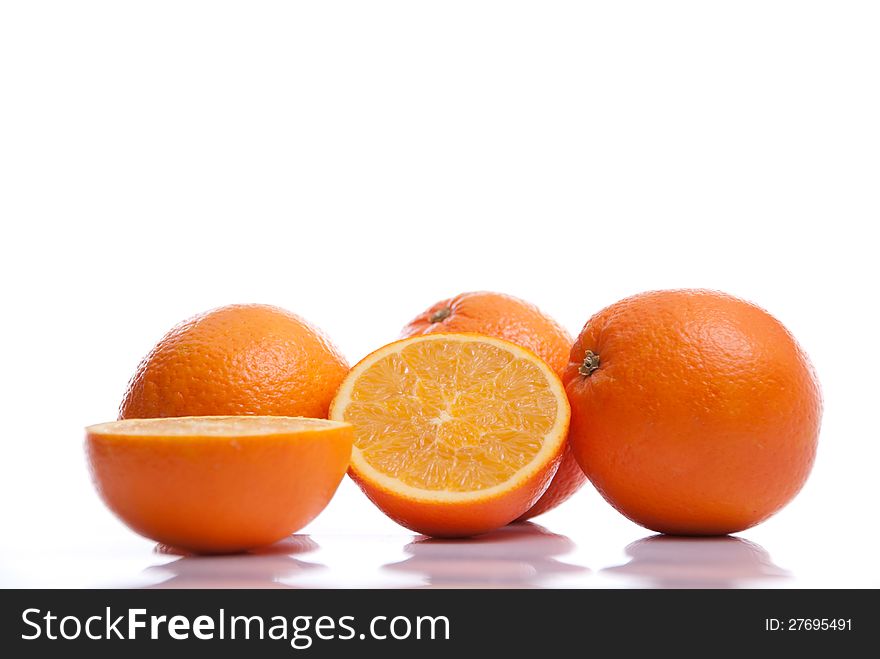 Fresh healthy whole and halved oranges lying on white background. Fresh healthy whole and halved oranges lying on white background