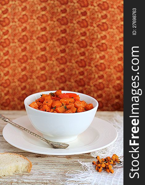 Pumpkin stew in a bowl on a wooden table. Pumpkin stew in a bowl on a wooden table.