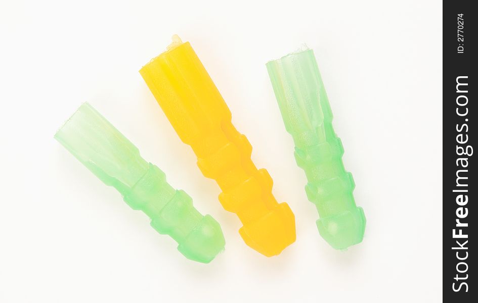 Three dowels in green and yellow on a white surface. Three dowels in green and yellow on a white surface