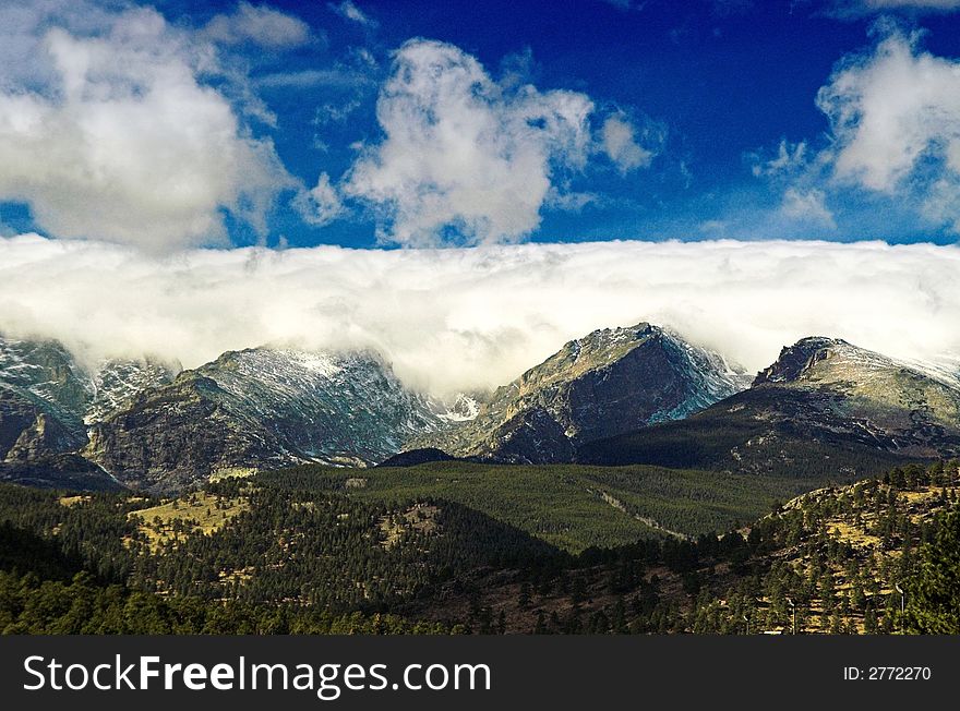 An incoming Winter Storm in Colorado, just outside Rocky Mountain National Park in Colorado, showing mountains, blue sky, and clouds