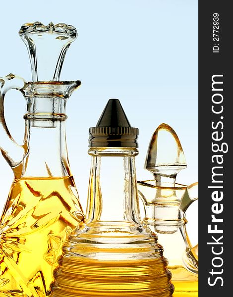 Three olive oil bottles on blue background .