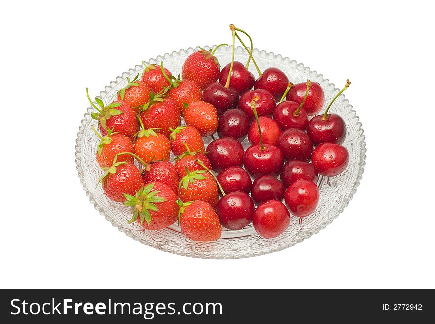 Strawberries and cherries on a glass dish, isolated on white background. Strawberries and cherries on a glass dish, isolated on white background