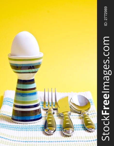 Boiled egg in tall striped egg-cup