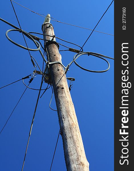 Telephone post against blue sky