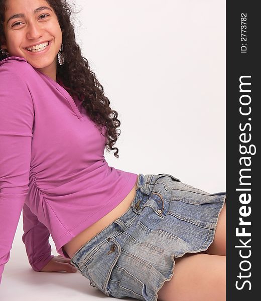 An beautiful young girl in an denim mini skirt is sitting on the floor and
her long dark curly hair hanging down on white background. An beautiful young girl in an denim mini skirt is sitting on the floor and
her long dark curly hair hanging down on white background.