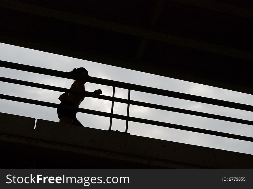 Young woman in silhouette running across a bridge. Useful as business metaphor such as training for success. Young woman in silhouette running across a bridge. Useful as business metaphor such as training for success.
