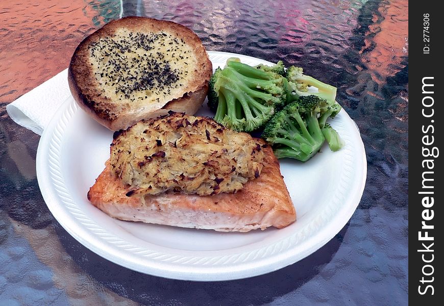 Dinner of salmon stuffed with crabmeat with brocolli and garlic bread on the side. Dinner of salmon stuffed with crabmeat with brocolli and garlic bread on the side