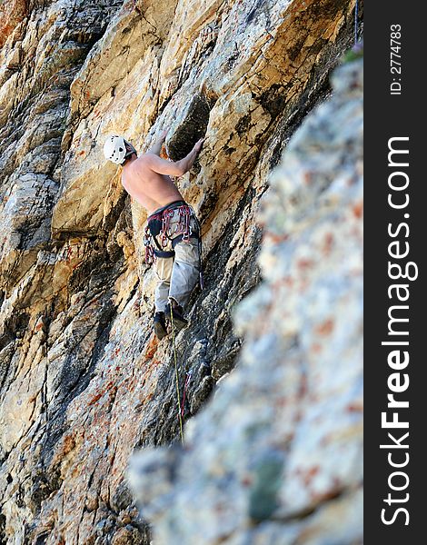 A man on a rock climb with textured rock. A man on a rock climb with textured rock