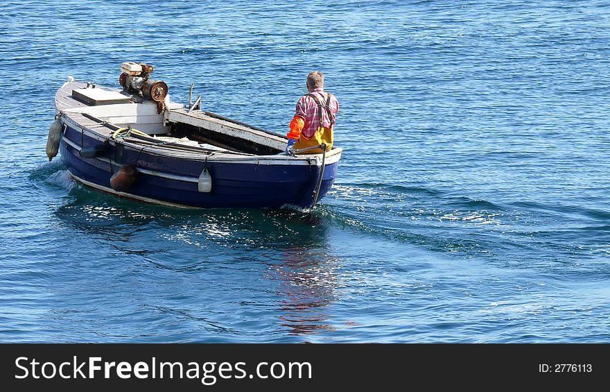 A fisherman going out on his small boat to lift the lobster/crab pots (creels). A fisherman going out on his small boat to lift the lobster/crab pots (creels).