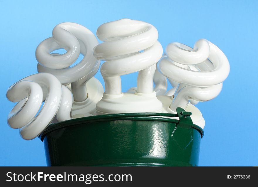 Electric bulbs on a bucket over blue background