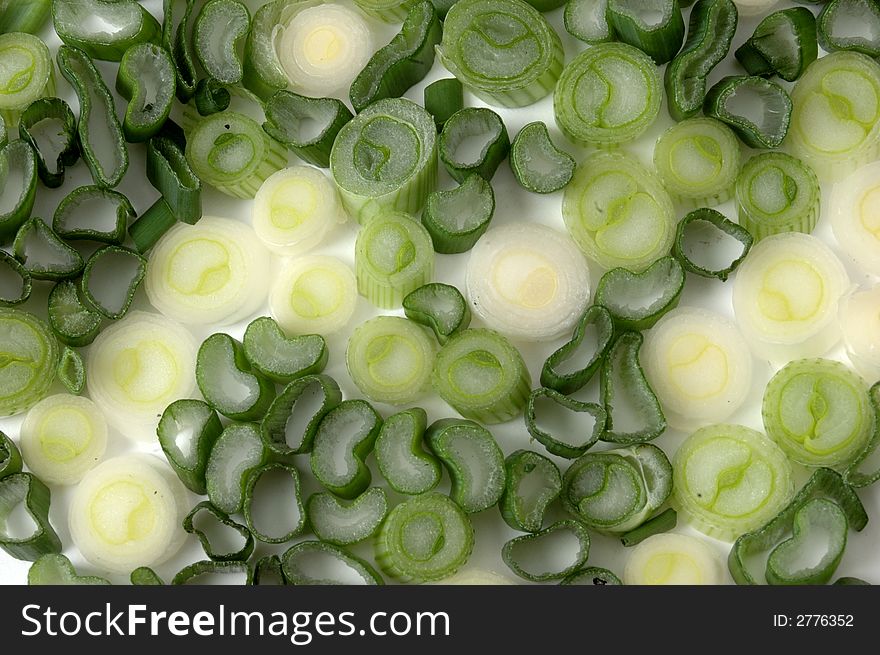 Peaces of green scallions on white. Peaces of green scallions on white
