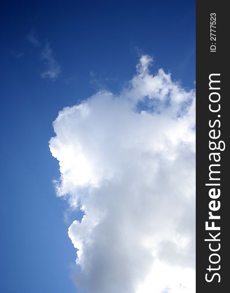 Deep blue sky with white fluffy cloud