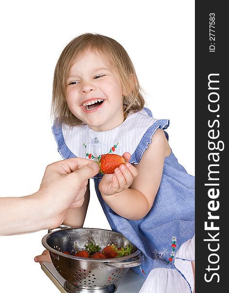 The girl eats a strawberry on an isolated background