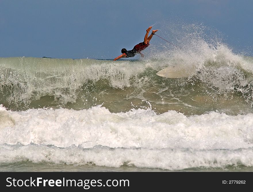 Surfer takes off on a wave in Thailand. Surfer takes off on a wave in Thailand