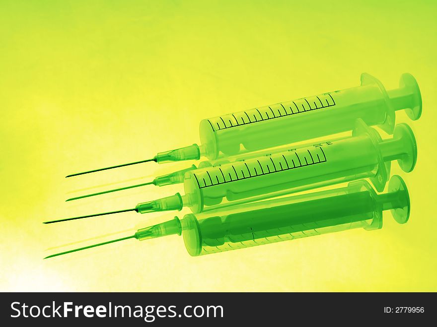 Two disposable syringes on green background. Two disposable syringes on green background