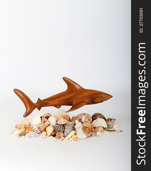 Wooden Carved Shark Hovering Over Seashells. Wooden Carved Shark Hovering Over Seashells