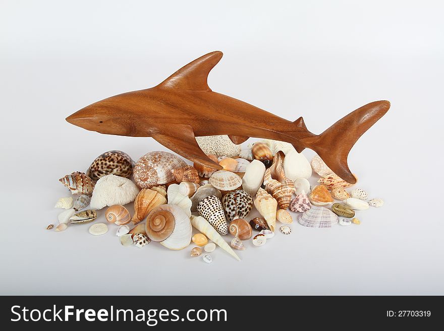 Wooden Carved Shark Hovering Over Seashells. Wooden Carved Shark Hovering Over Seashells