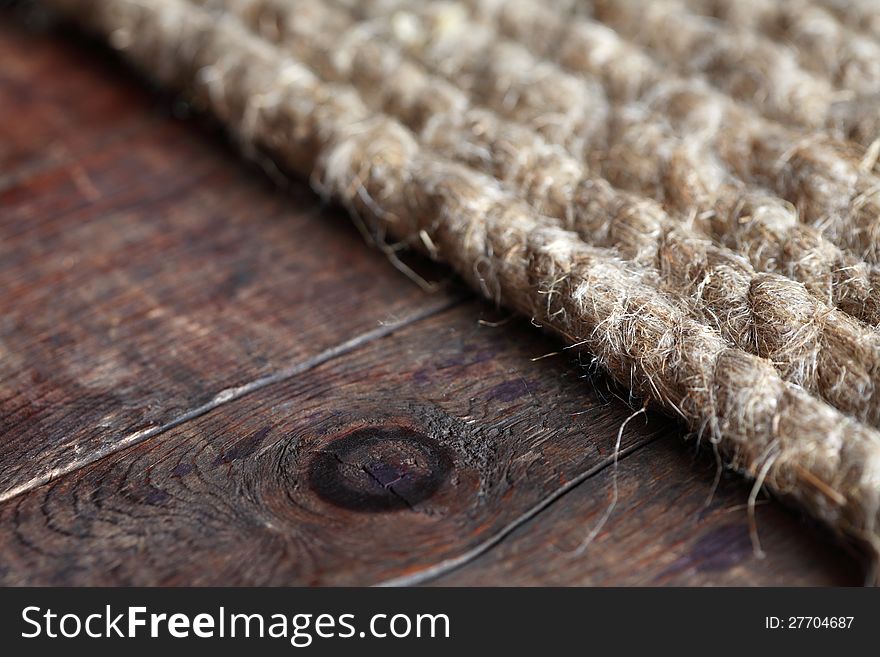 Closeup of old hemp rope on dark wooden surface. Closeup of old hemp rope on dark wooden surface