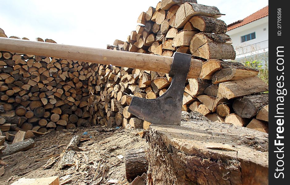 DRAMA, GREECE - OCT 8: Wood axe and wood pile outdoor prepared for winter on October 4, 2010 in Drama,Greece. DRAMA, GREECE - OCT 8: Wood axe and wood pile outdoor prepared for winter on October 4, 2010 in Drama,Greece.