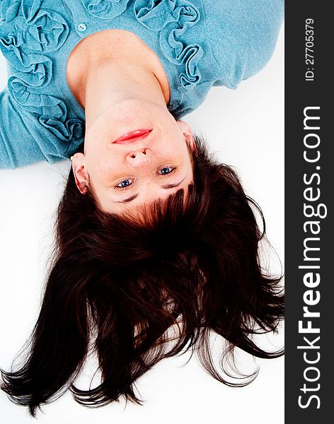 The girl poses while lying on the floor isolated on white background