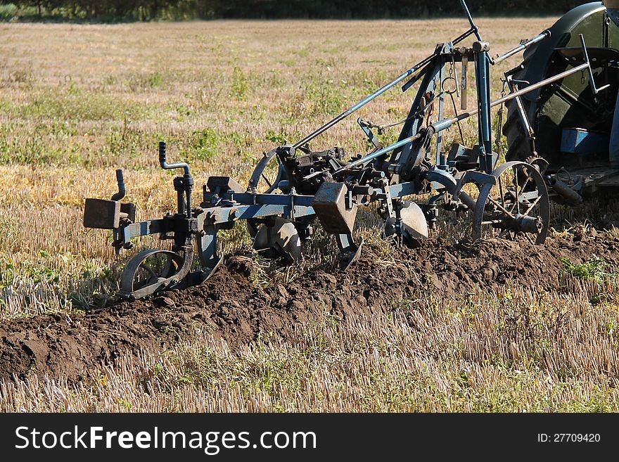 A Vintage Plough Cutting a Furrow in a Field. A Vintage Plough Cutting a Furrow in a Field.