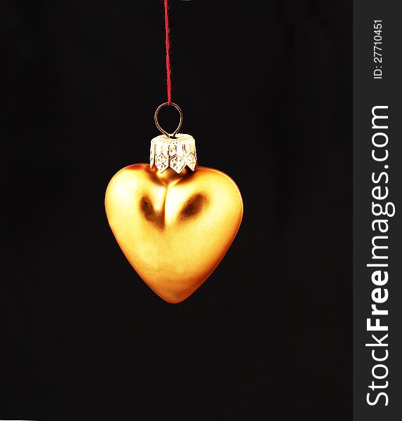 Hanging Christmas yellow heart  isolated on black background. Hanging Christmas yellow heart  isolated on black background